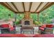 Inviting covered patio with stone fireplace and comfortable seating arrangement at 3230 Sundew Nw Dr, Acworth, GA 30101