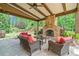 Entertainers patio with an outdoor stone fireplace and wicker seating area at 3230 Sundew Nw Dr, Acworth, GA 30101
