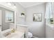 Fresh bathroom with white vanity, toilet, and modern fixtures beneath decorative art and a shelf at 267 Somerlane Pl, Avondale Estates, GA 30002