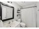 Functional bathroom with a shower-tub combo, decorative shower curtain, and modern shelving for storage and decor at 267 Somerlane Pl, Avondale Estates, GA 30002