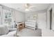 Bright Bedroom with a white crib, changing table, and a comfortable gray armchair, complemented by natural light at 267 Somerlane Pl, Avondale Estates, GA 30002