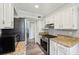 Modern kitchen with stainless steel appliances, granite countertops, and white cabinets at 267 Somerlane Pl, Avondale Estates, GA 30002