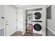 Efficient laundry area with stacked washer and dryer, storage shelves, and convenient access near the entrance at 267 Somerlane Pl, Avondale Estates, GA 30002