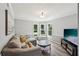 Inviting living room with a comfortable sofa, large windows, and a modern entertainment center at 267 Somerlane Pl, Avondale Estates, GA 30002