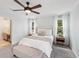Serene main bedroom features a ceiling fan, a plush bed, and a glimpse into the ensuite bathroom at 267 Somerlane Pl, Avondale Estates, GA 30002
