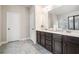 Bathroom featuring dual sink vanity with dark cabinets and light-colored marble tile flooring at 3415 Linstead Ct, Loganville, GA 30052