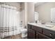 Well-lit bathroom featuring modern fixtures, wood look floors, and a shower-tub combo at 3415 Linstead Ct, Loganville, GA 30052