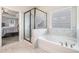Elegant bathroom with marble tile surround, separate shower and soaking tub and window blinds at 3415 Linstead Ct, Loganville, GA 30052