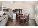 Open concept dining room with a dark wood table and modern chandelier, next to the island kitchen at 3415 Linstead Ct, Loganville, GA 30052
