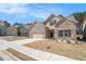 Attractive home featuring a brick facade, two-car garage, well-maintained lawn, and sidewalks at 3415 Linstead Ct, Loganville, GA 30052