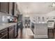 Modern kitchen with stainless steel appliances, gray backsplash, an island, and open floorplan at 3415 Linstead Ct, Loganville, GA 30052