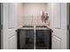 Bright laundry room with a modern, front-loading washer and dryer and overhead wire shelving at 3415 Linstead Ct, Loganville, GA 30052