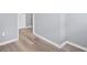 An empty room features grey walls, wood-look floors, and white trim, offering a blank canvas for personalization at 6997 Vesta Brook Dr, Morrow, GA 30260