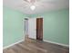 Bedroom with green walls, wood-look floors, ceiling fan, closet and white trim at 6997 Vesta Brook Dr, Morrow, GA 30260