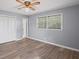 Bedroom featuring a window, neutral gray walls, wood-look floors, ceiling fan and white trim with closet at 6997 Vesta Brook Dr, Morrow, GA 30260