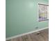 Bedroom with green walls, white trim, wood-look floors, and window bringing in natural light at 6997 Vesta Brook Dr, Morrow, GA 30260