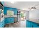 Bright kitchen features blue cabinets, stainless steel appliances, granite counters, and island with sliding doors to outdoor space at 6997 Vesta Brook Dr, Morrow, GA 30260