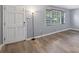 Bright living room featuring gray walls, hardwood floors, a front door and a large window at 6997 Vesta Brook Dr, Morrow, GA 30260