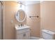 Cozy bathroom with circular mirror, undermount sink, and white cabinets at 1584 Water Springs Way, Dacula, GA 30019
