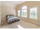 Sun-filled bedroom with multiple windows, neutral carpet, and a simple bed frame at 1584 Water Springs Way, Dacula, GA 30019