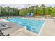 Community pool with a slide, lounge chairs, and a tennis court in the background at 1584 Water Springs Way, Dacula, GA 30019