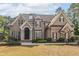 Charming two-story brick home featuring manicured lawn and mature trees at 1584 Water Springs Way, Dacula, GA 30019