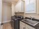 Well-appointed laundry room with front loading machines, sink, and ample storage at 1584 Water Springs Way, Dacula, GA 30019