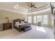Tranquil main bedroom features a tray ceiling, fireplace, and sitting area by the windows at 1584 Water Springs Way, Dacula, GA 30019