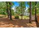 Serene backyard featuring mature trees, a lush lawn, and a charming covered deck at 40 Polo Xing, Hiram, GA 30141