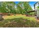 Expansive backyard with lush green lawn, mature trees, wooden fence, and covered back deck at 40 Polo Xing, Hiram, GA 30141