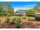 A spacious backyard with a lush green lawn, mature trees, wood fence, and a relaxing covered deck at 40 Polo Xing, Hiram, GA 30141