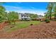 A beautifully maintained backyard with lush lawn, mature trees, a wooden fence, and a covered deck at 40 Polo Xing, Hiram, GA 30141