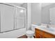 Bathroom featuring a tub-shower with a sliding glass door, toilet, and wood vanity with sink at 40 Polo Xing, Hiram, GA 30141
