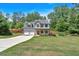 View of a two-story home with a well-manicured lawn and long driveway at 40 Polo Xing, Hiram, GA 30141