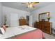 Comfortable bedroom with wood furniture, carpet, and ceiling fan at 4690 Hopewell Manor Dr, Cumming, GA 30028