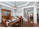 Dining room with hardwood floors, elegant pendant light, and view to the living room at 4690 Hopewell Manor Dr, Cumming, GA 30028