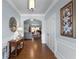 Inviting foyer featuring hardwood floors, decorative mirror, console table, and view into the living room at 4690 Hopewell Manor Dr, Cumming, GA 30028