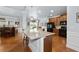 Open concept kitchen featuring a kitchen island, bar area, granite countertops, and hardwood flooring at 4690 Hopewell Manor Dr, Cumming, GA 30028