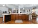 Kitchen island with stainless steel dishwasher and sink adjacent to an eat-in kitchen area at 4690 Hopewell Manor Dr, Cumming, GA 30028