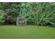 Large green backyard with a shed surrounded by mature trees and a wooden fence at 6031 Hitt Lake Ct, Stone Mountain, GA 30087