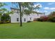Spacious backyard with a large green lawn, mature tree, and a red wooden deck at 6031 Hitt Lake Ct, Stone Mountain, GA 30087