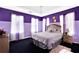 Bedroom with purple walls, neutral carpet, natural lighting, and cozy bed that is perfect for a guest or space at 6031 Hitt Lake Ct, Stone Mountain, GA 30087