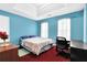 This bedroom features bright blue walls, neutral carpet, and a cozy bed with a desk, perfect for a guest or space at 6031 Hitt Lake Ct, Stone Mountain, GA 30087