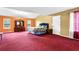 Spacious primary bedroom featuring neutral walls, plush red carpet, and ample natural light at 6031 Hitt Lake Ct, Stone Mountain, GA 30087