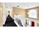 Well-lit hallway with white railing and neutral walls leading to various rooms at 6031 Hitt Lake Ct, Stone Mountain, GA 30087