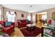 Inviting living room with hardwood floors, red couches, and ample natural light at 6031 Hitt Lake Ct, Stone Mountain, GA 30087