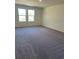 A bedroom features a neutral color scheme and plush carpet, with two windows at 7785 Sudbury Cir, Covington, GA 30014