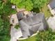 Aerial view showcases the home's layout, including the patio, putting green, and surrounding greenery at 10000 Groomsbridge Rd, Johns Creek, GA 30022