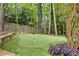Backyard putting green is nestled among mature trees and landscaping at 10000 Groomsbridge Rd, Johns Creek, GA 30022