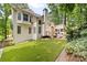 Expansive backyard with manicured lawn, rear building elevation, and verdant trees at 10000 Groomsbridge Rd, Johns Creek, GA 30022